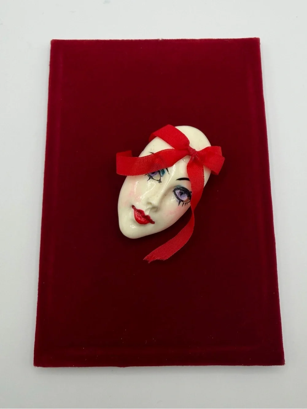 Vintage Face Brooch with Red Ribbon Accent